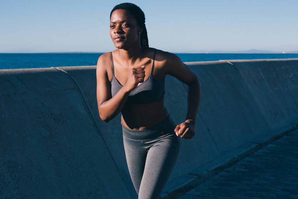 Mulher negra correndo, para otimizar o exercício ela pode usar os treinos personalizados do app Adidas Running by Runtastic