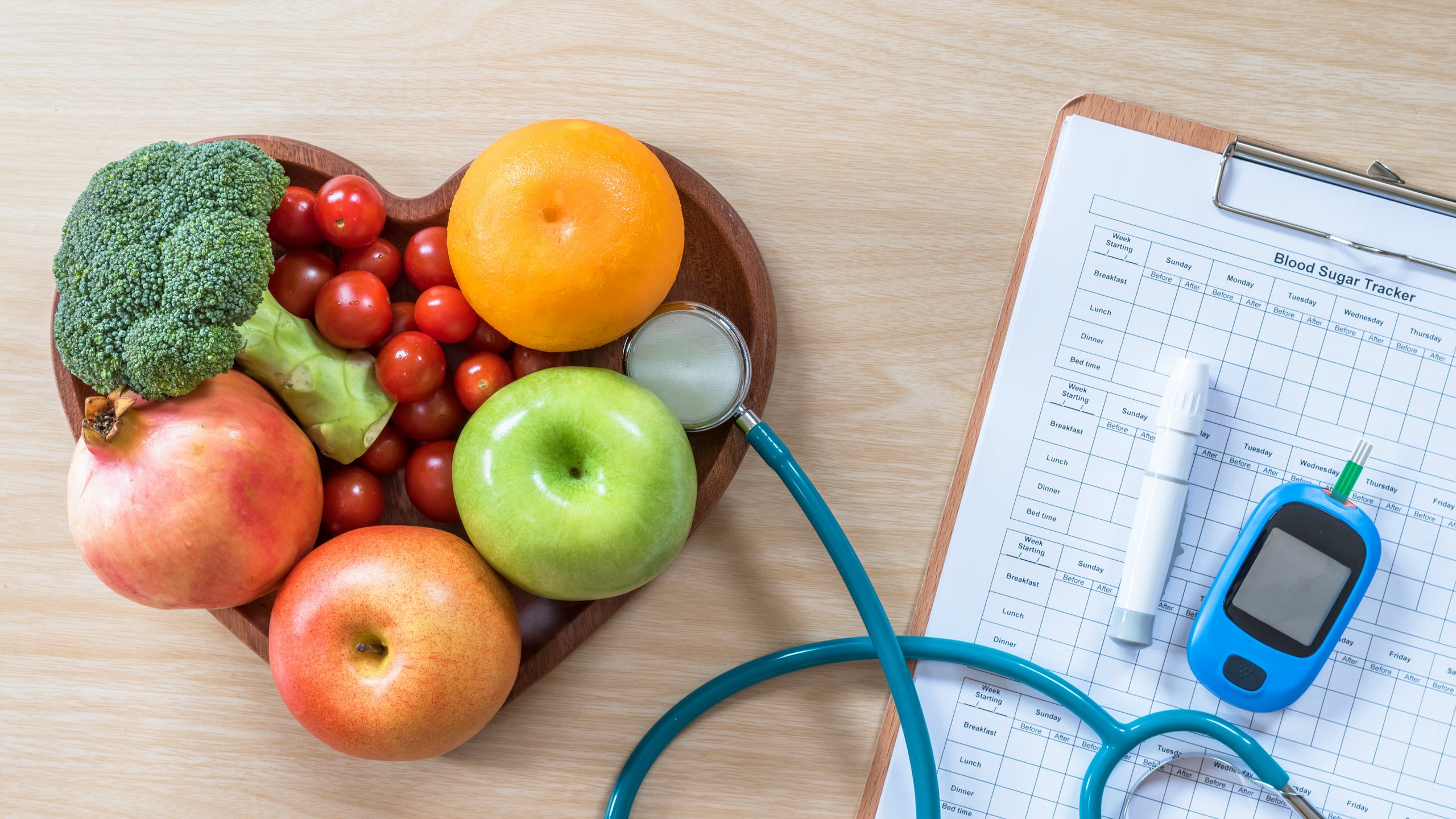 Frutas, ficha de paciente, estetoscópio e medidor de glicose