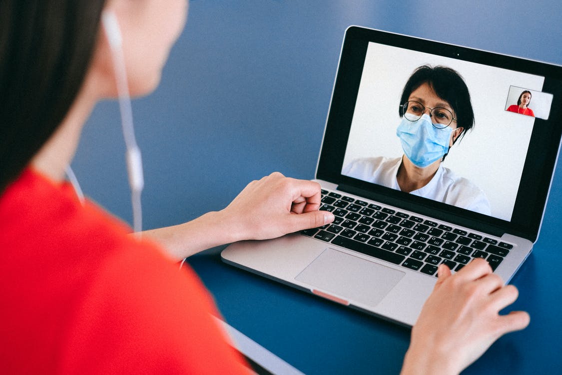 Mulher fazendo consulta online com médica