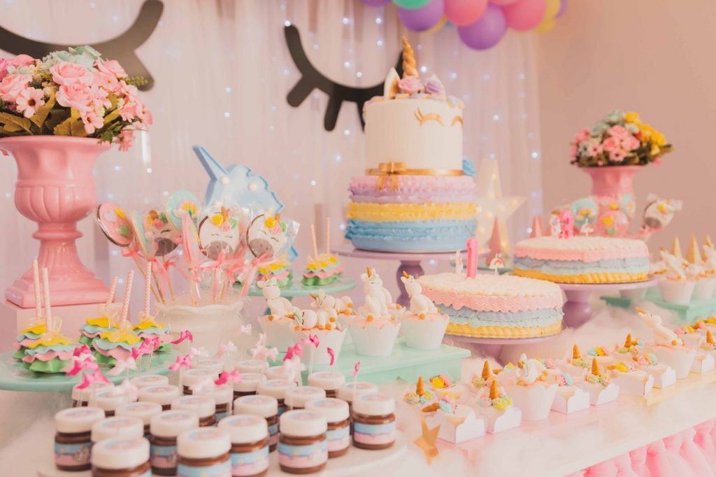bolo de três andares e doces de festa sobre mesa, bolos caprichados são parte do Curso de confeitaria Mundo Doce da Mari