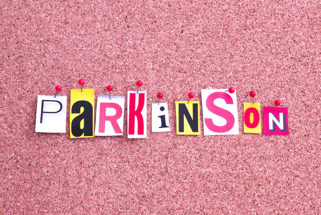 Parkinson escrito em recortes e fundo rosa