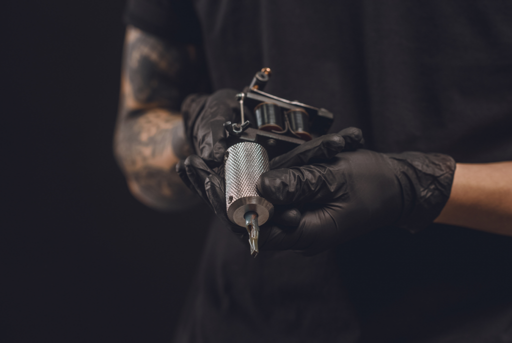 Tatuador segurando máquina de tatuagem