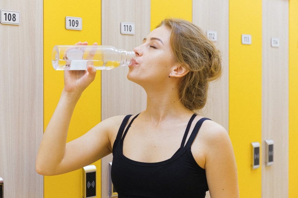 Mulher bebendo água para promover o emagrecimento saudável e rápido