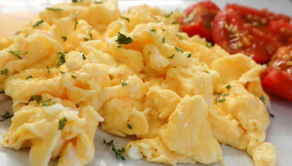 Ovos mexidos, que são uma das opções de comida leve para a noite. E mini tomates de acompanhamento.