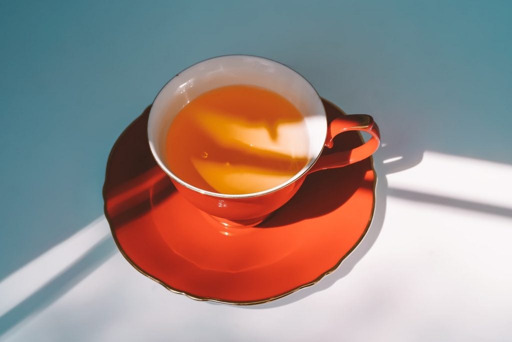 Pires e xícara com chá de açafrão, uma das maneiras de Como tomar açafrão para emagrecer