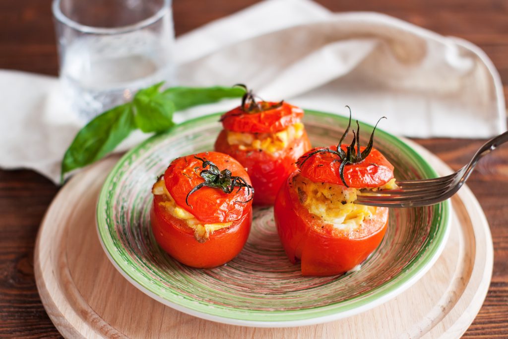 Tomates assados recheados com queijo e ovos, sendo essa uma das receitas para almoço saudável e rápido