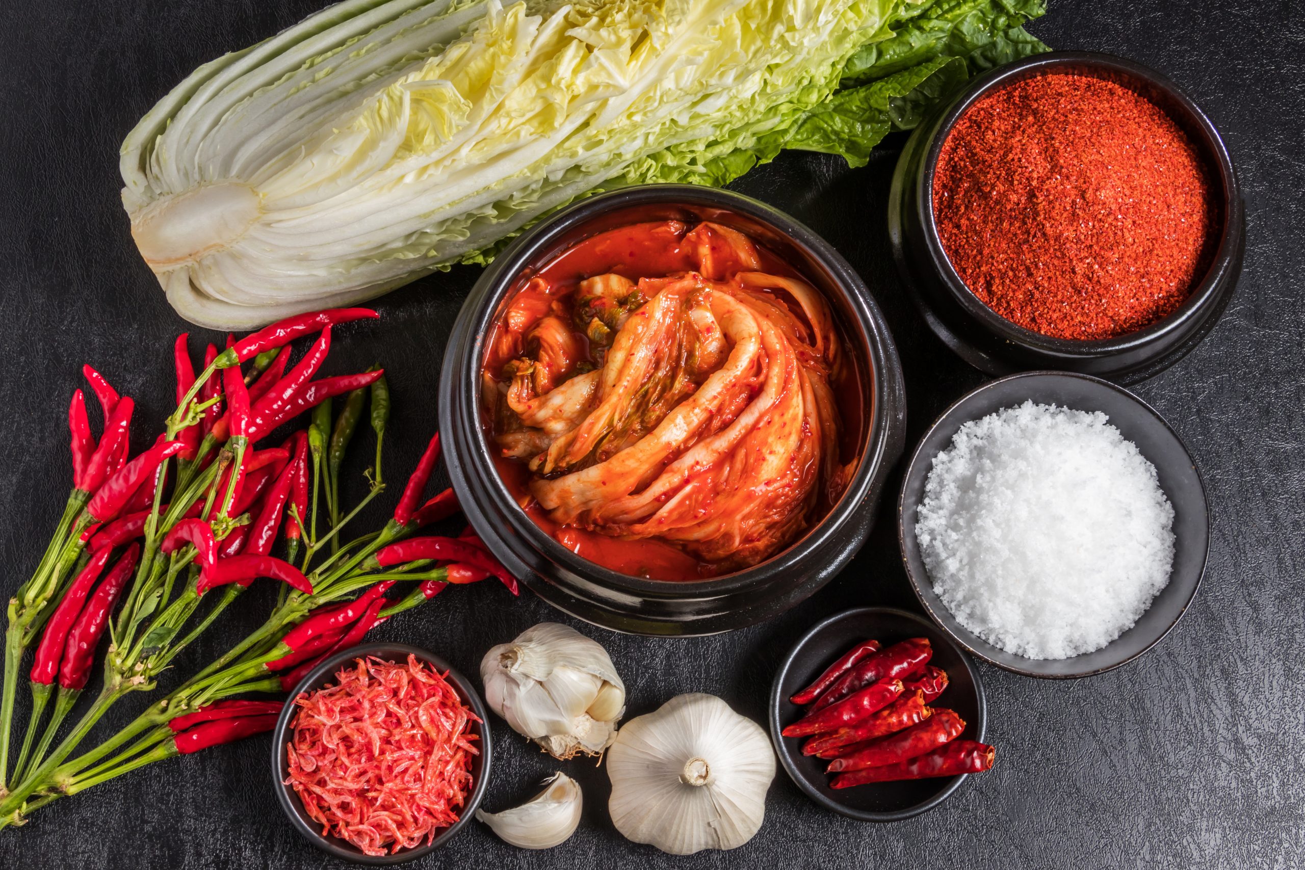 Ingredientes tradicionais para a preparação do kimchi em fundo escuro