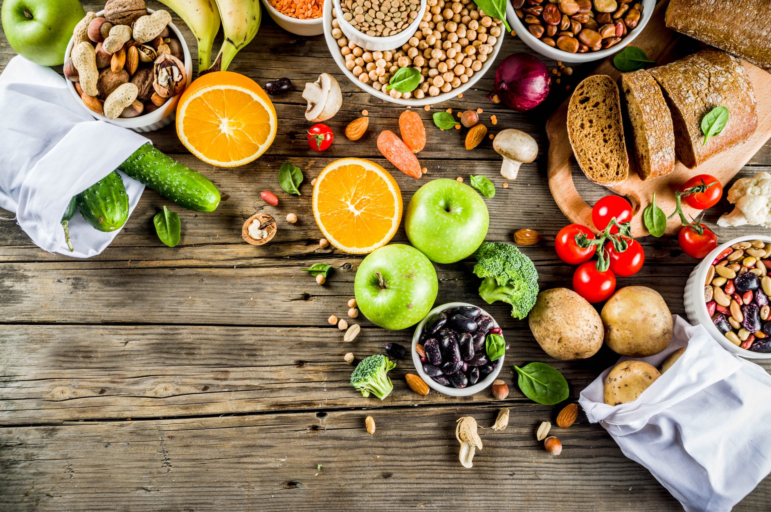 Dieta low carb. Legumes frescos, frutas, cereais, nozes, verduras em fundo de madeira