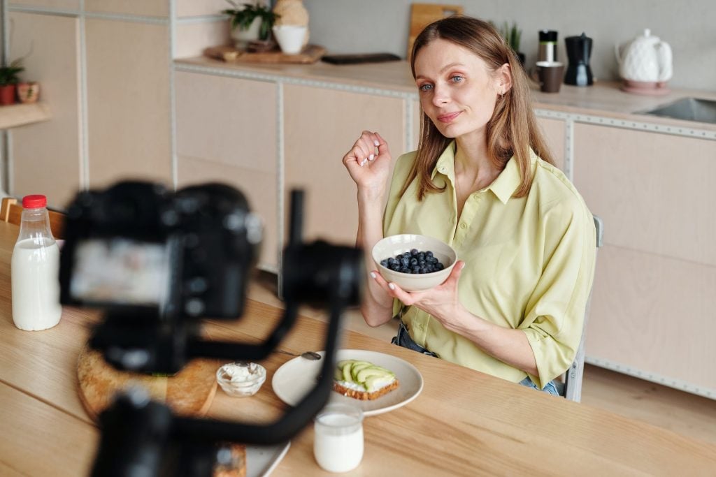 Mulher sendo filmada preparando café da manhã