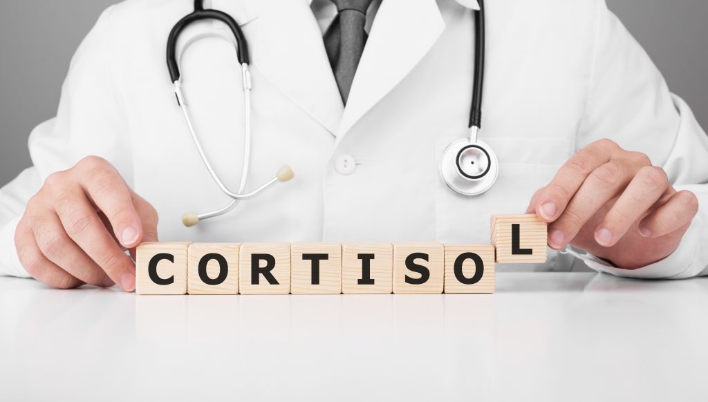 Médico formando palavra Cortisol com blocos