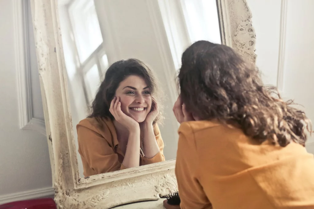 Mulher sorrindo olhando no espelho