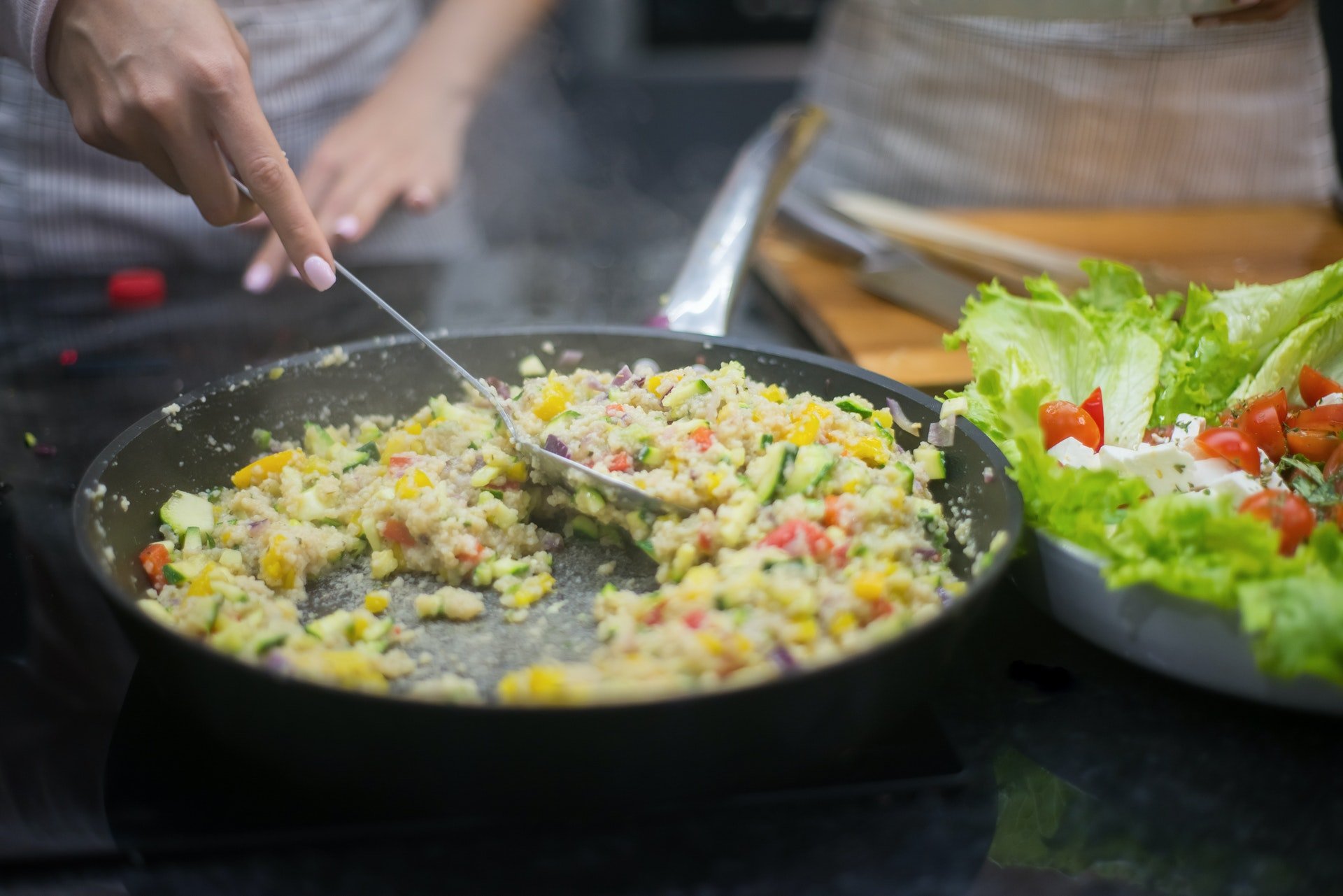 pessoa se servindo de comida e prato de salada