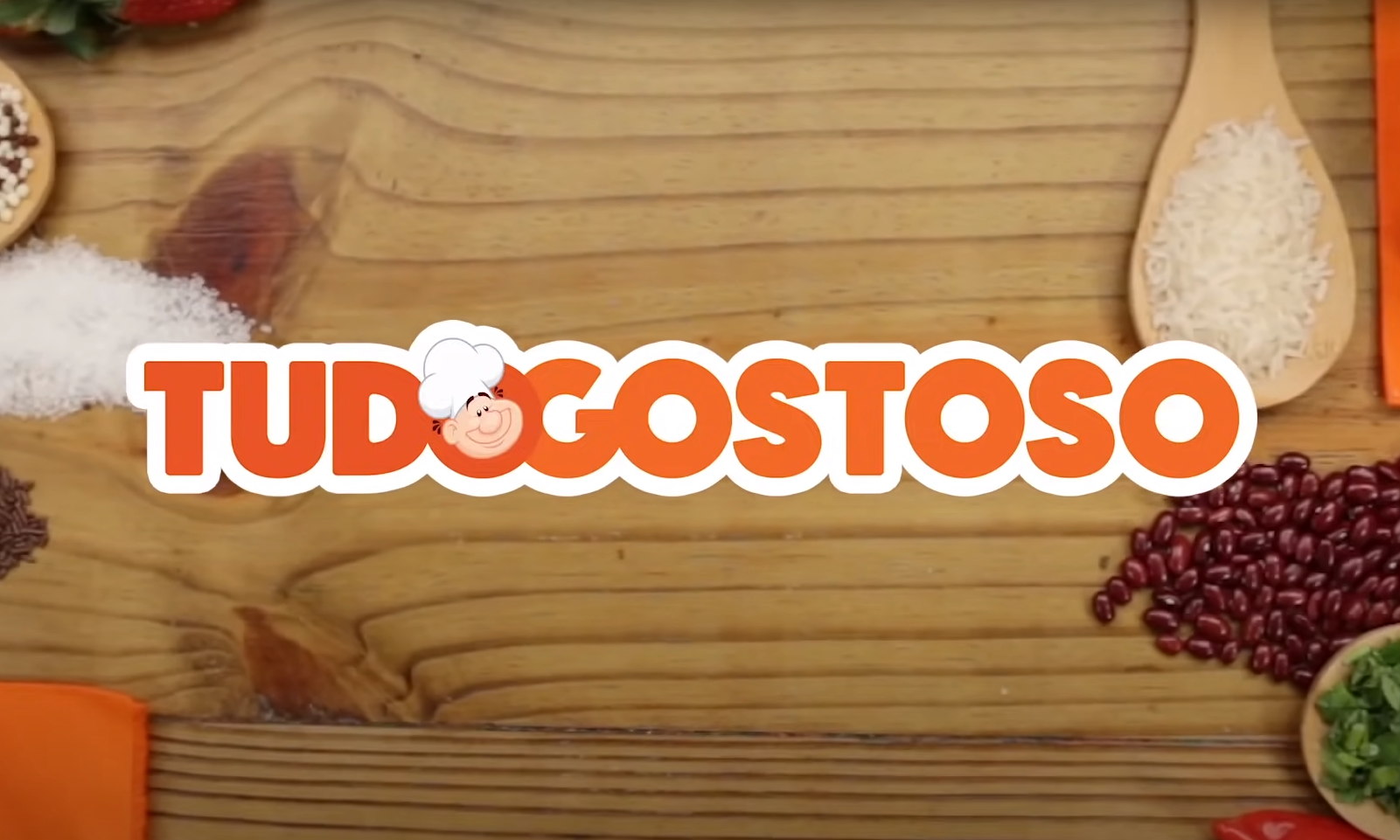 Logotipo laranja do App Tudo Gostoso sobre uma mesa com alimentos