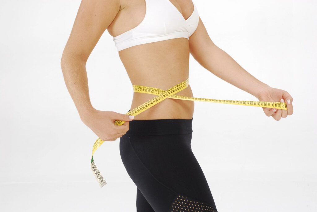 Mulher medindo sua cintura/barriga mais fina após o Desafio 19 dias