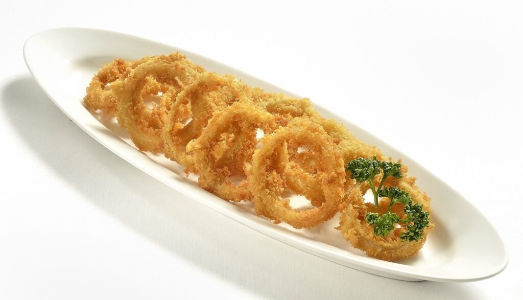 Onion rings sobre a mesa com toalha de mesa branca