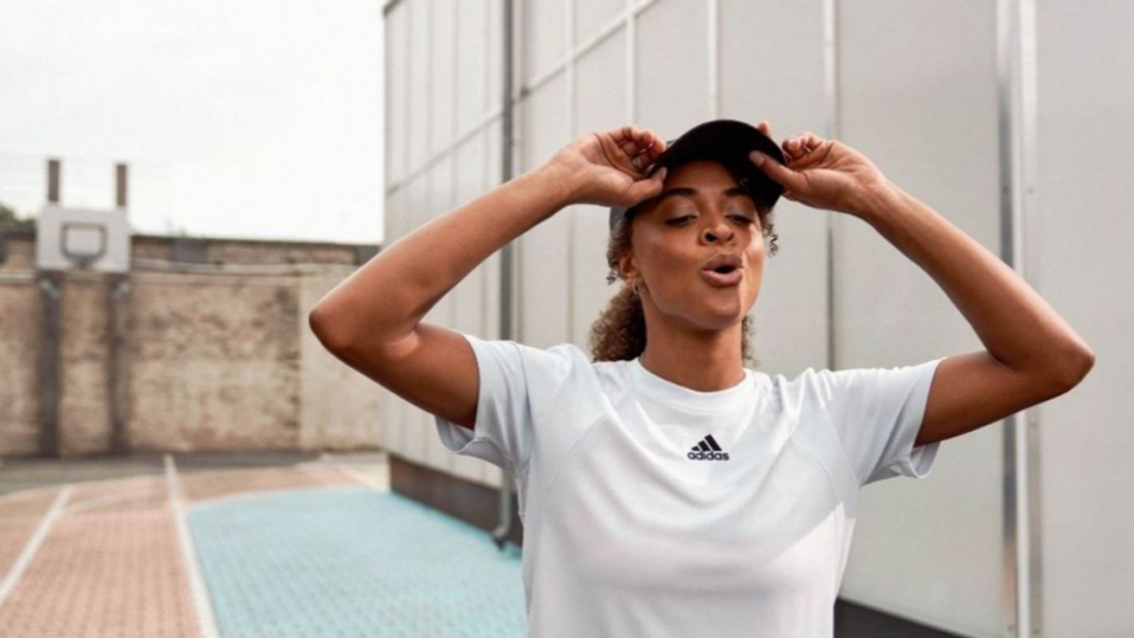Pessoa com camiseta branca da Adidas e boné