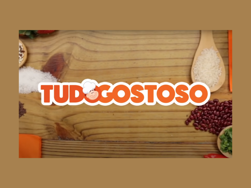 Logotipo laranja do App Tudo Gostoso sobre uma mesa com alimentos