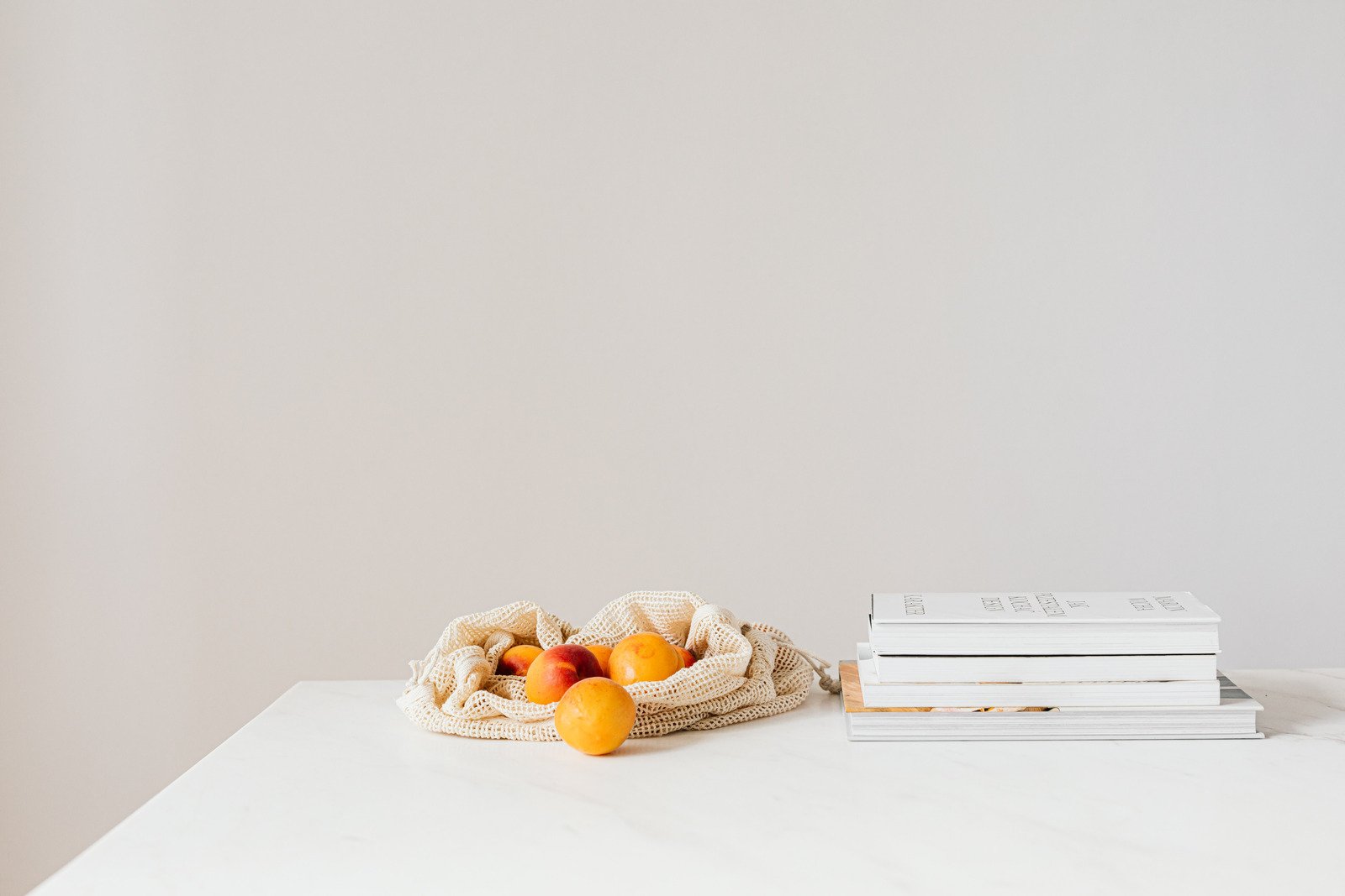 Frutas, possivelmente tangerinas, com livros ao lado, representando reeducação alimentar