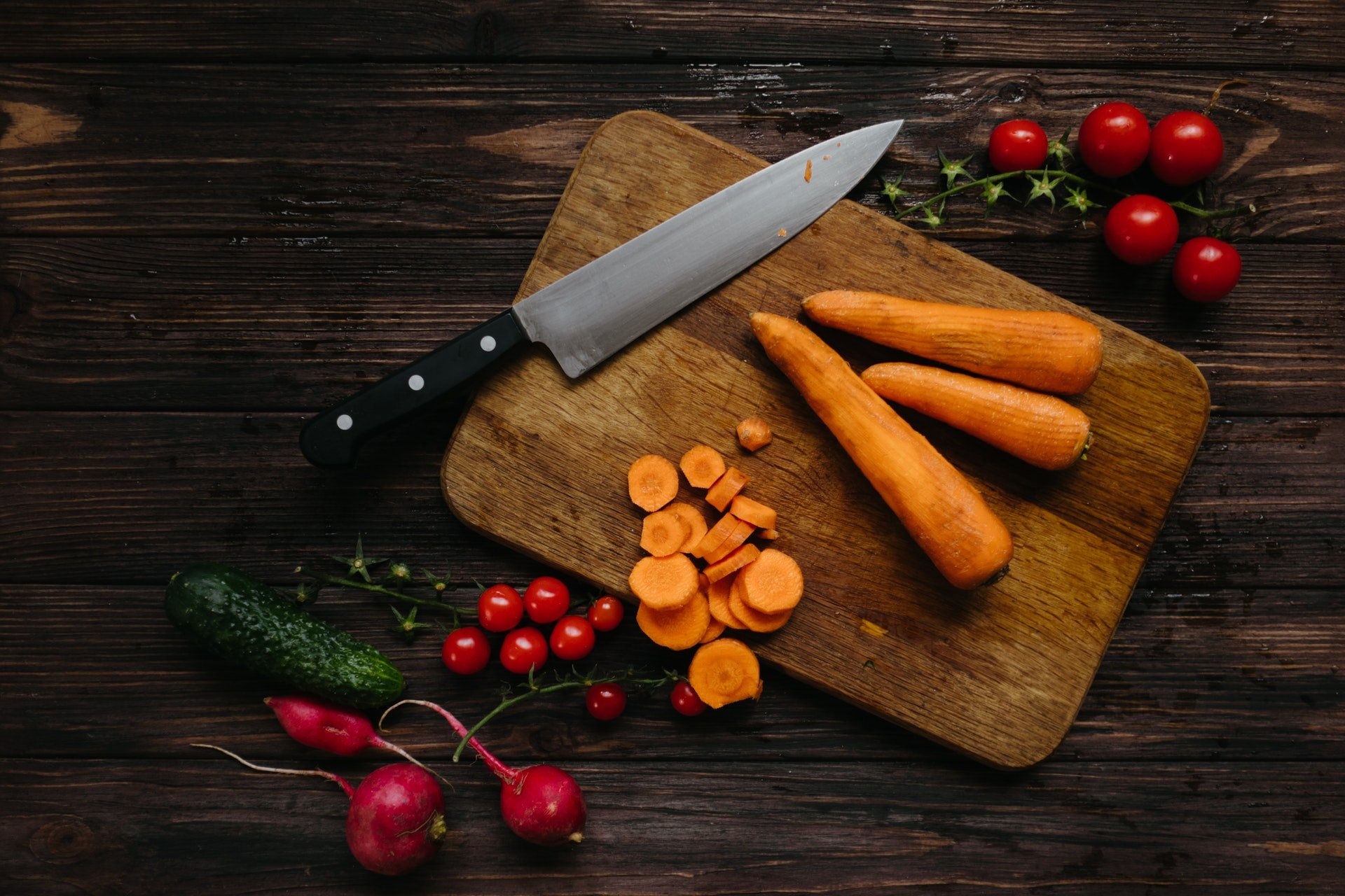 Tábua com cenoura, tomate e faca