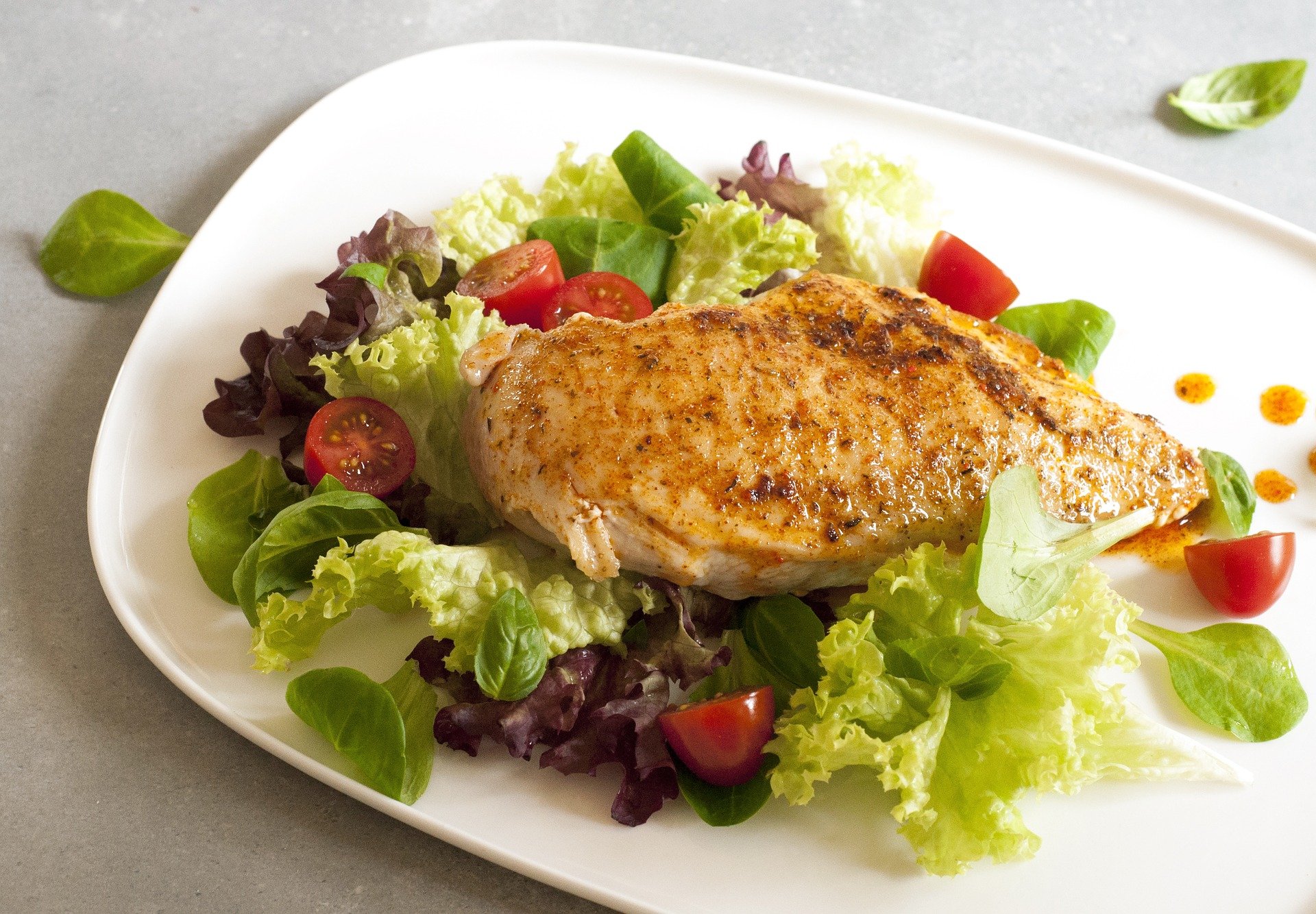 Prato com verduras, frango grelhado e tomate.