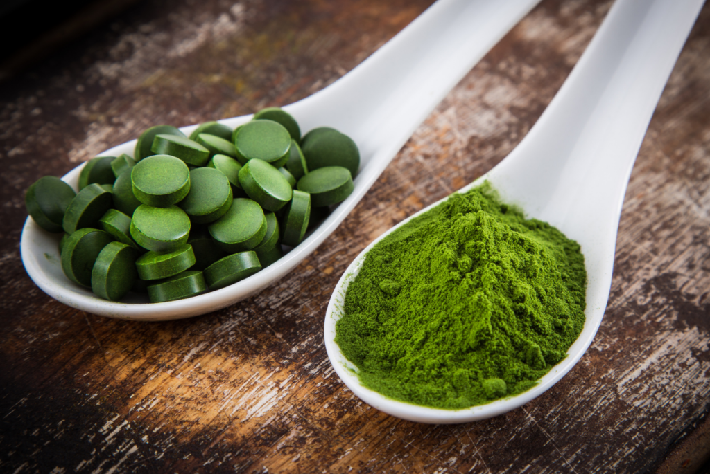 Colheres com pó e tabletes de chlorella