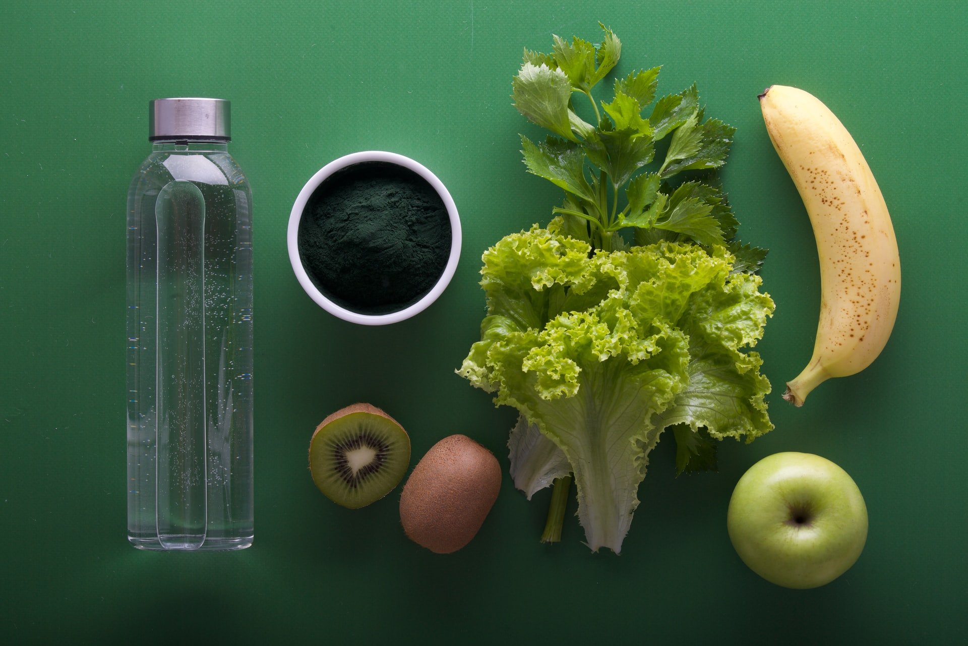 Frutas, verduras, garrafa de água em cima de mesa