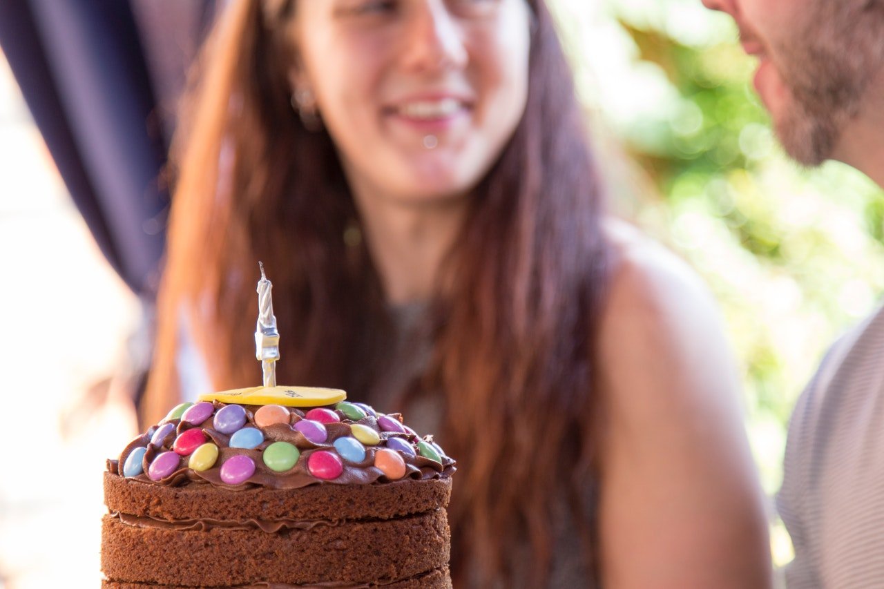 Bolo de aniversário de chocolate com pessoa ao fundo