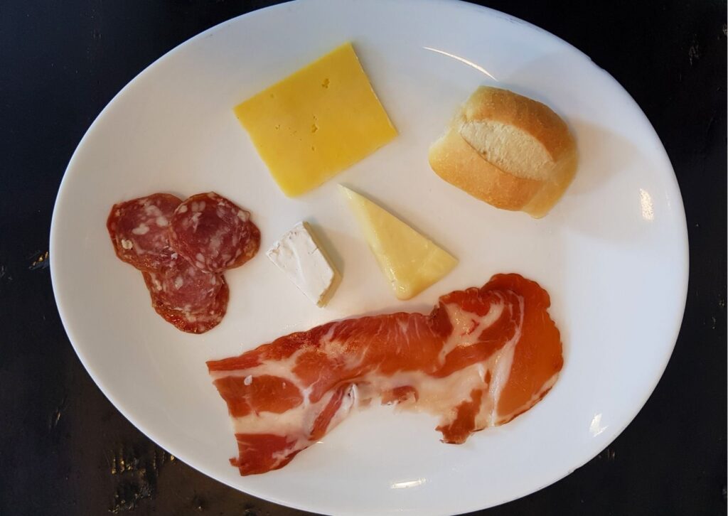 Prato com alguns pedaços de salame e queijo
