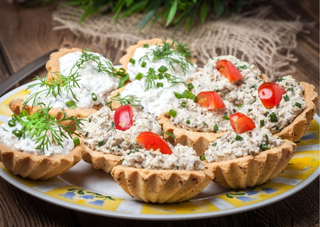 Várias torradas gourmet com patê de queijo com gorgonzola e tomates crus por cima