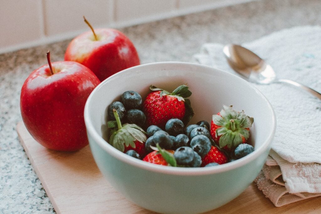 Tigela com morangos e blueberry; maçãs
