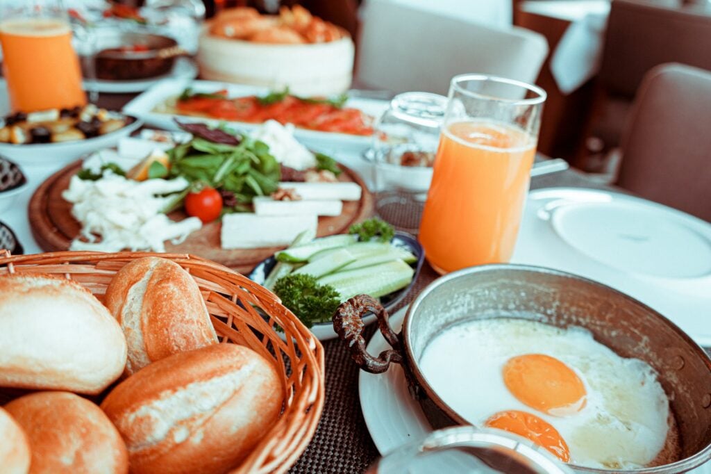 Café da manhã com pães, ovos e sucos