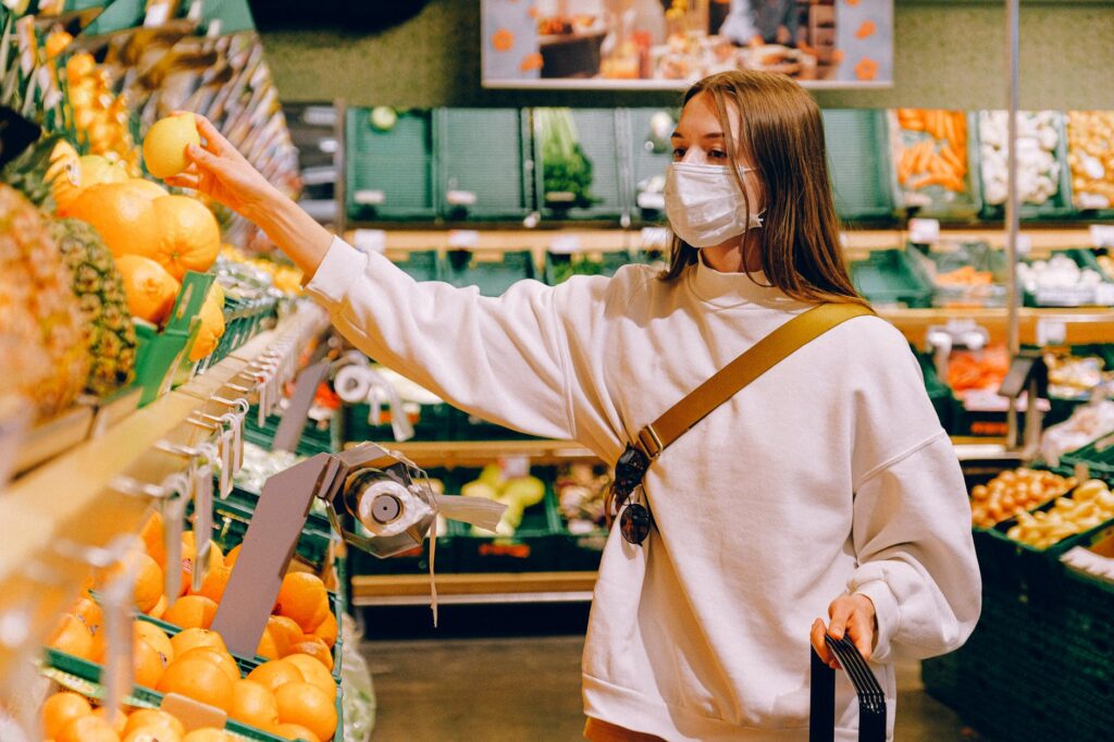 Mulher de máscara fazendo compras em mercado