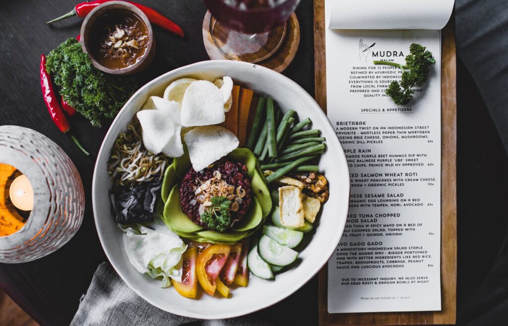 Prato de comida com grãos, vegetais, legumes; cardápio, temperos, copo, pimentas