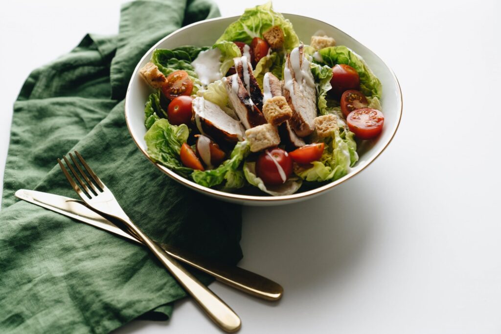 Prato de salada com pano, garfo e faca