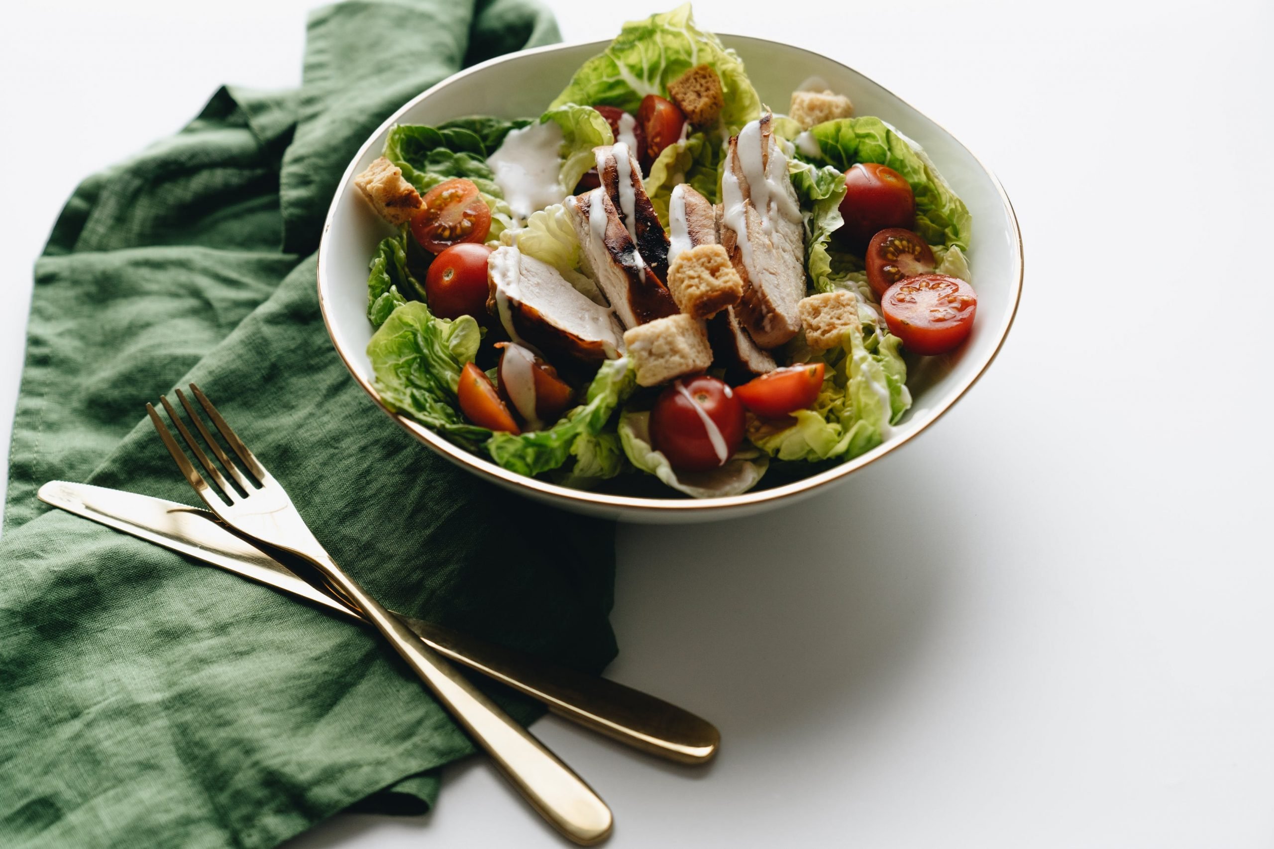 Prato de salada com pano, garfo e faca