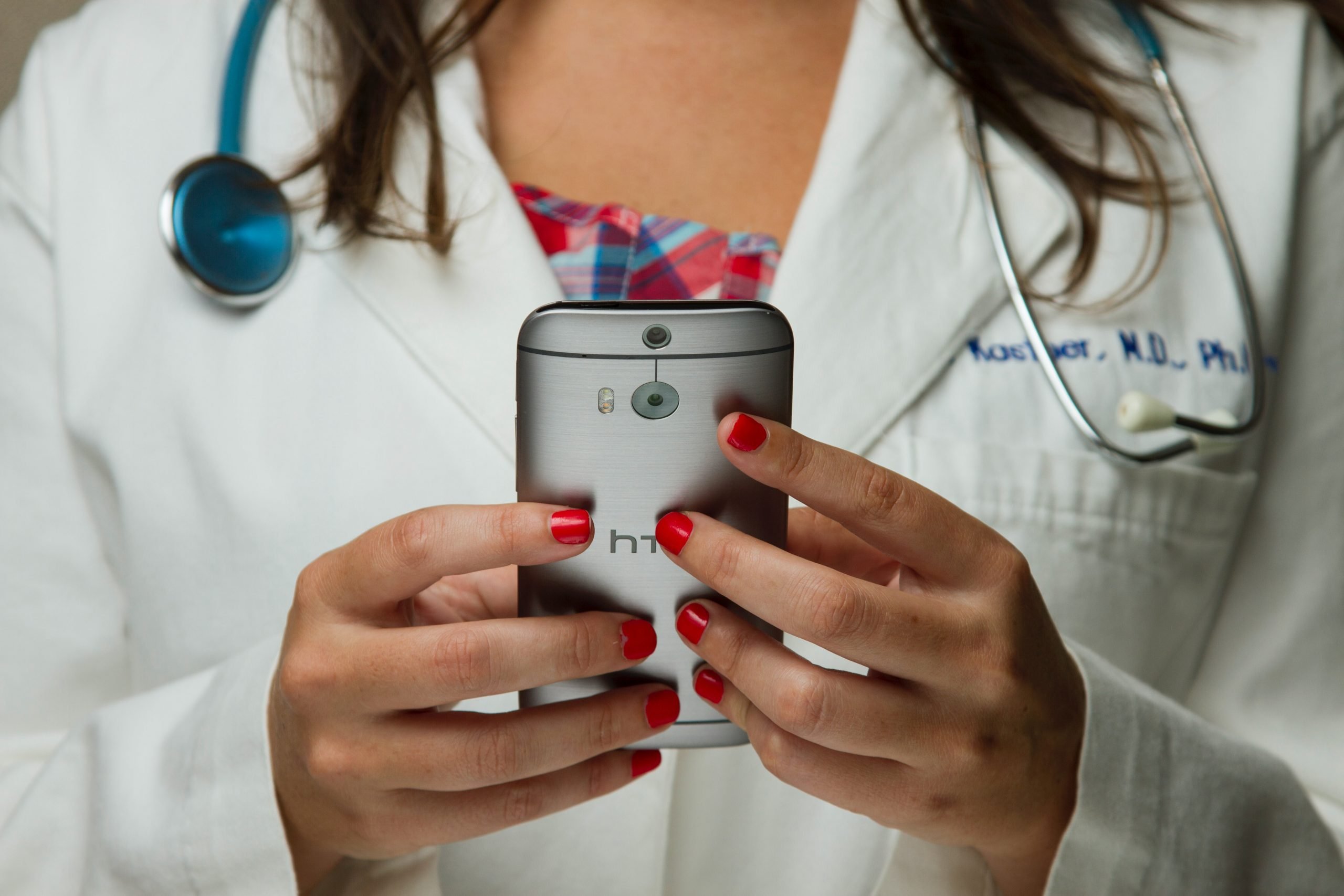 Médica com celular na mão