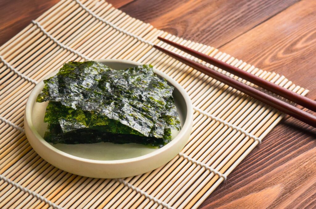Alga crocante, nori chips, sobre a mesa com palitinhos hashi