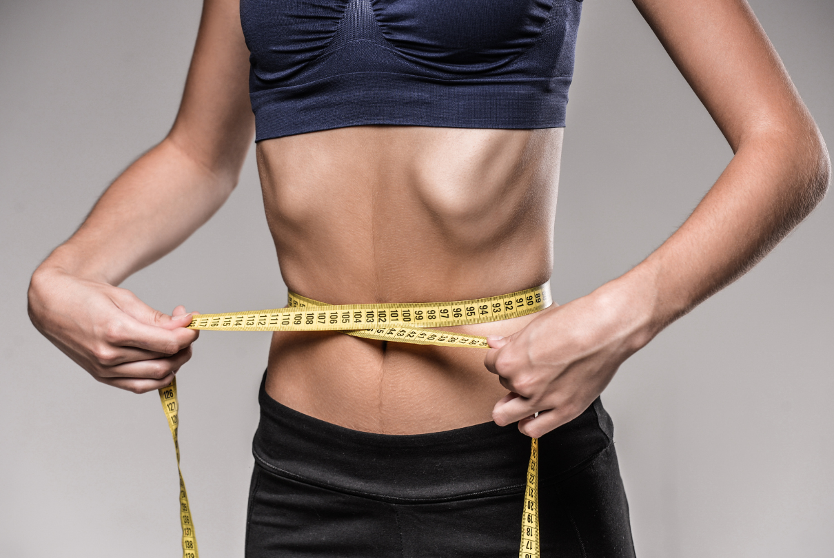 Mulher magra medindo a cintura