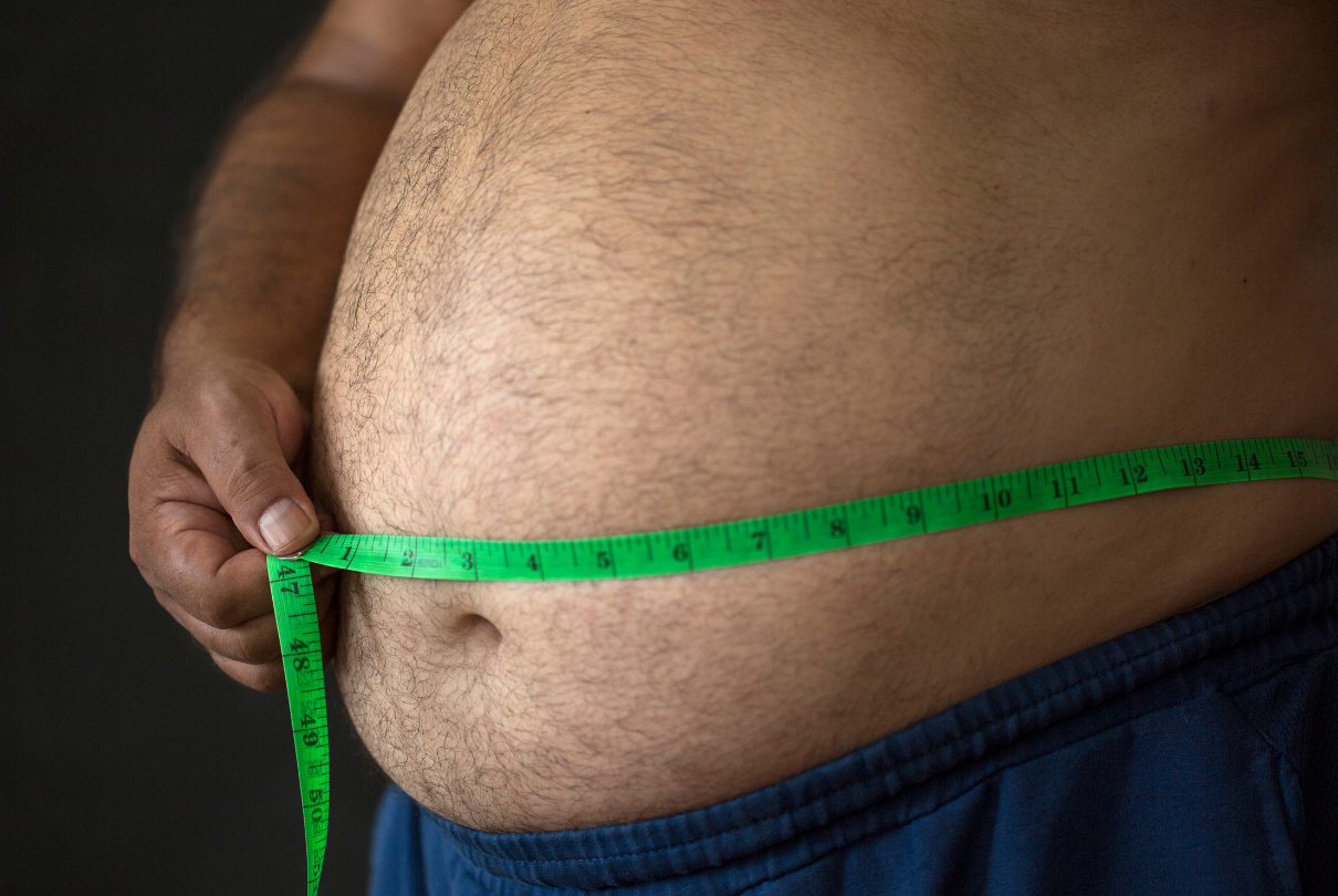 Homem com fita métrica na barriga