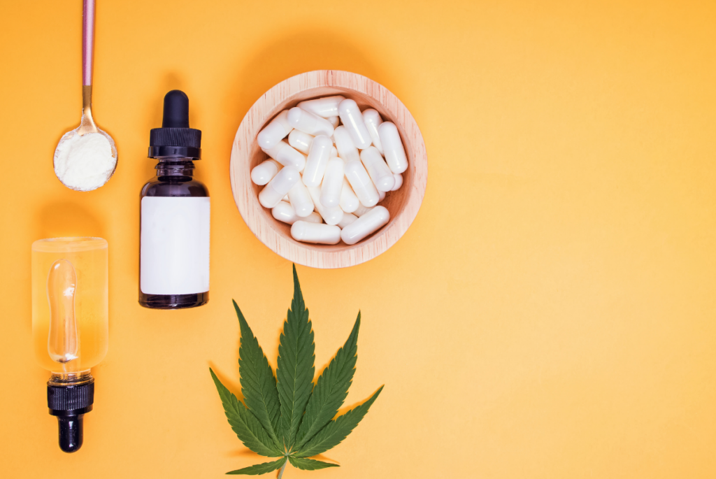 Conta gotas, cápsulas e folhas de cannabis no fundo amarelo