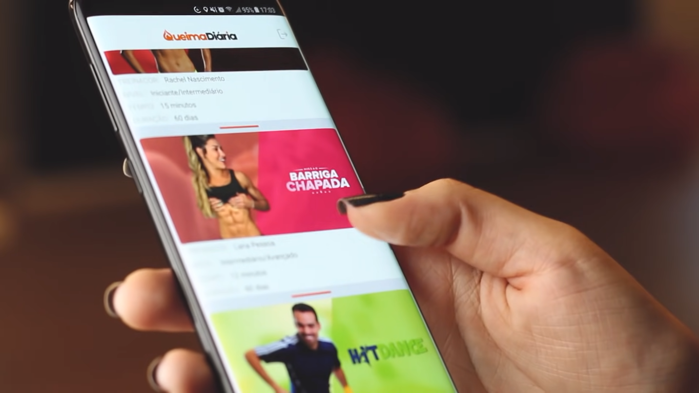 Pessoa segurando celular com aplicativo Queima Diária