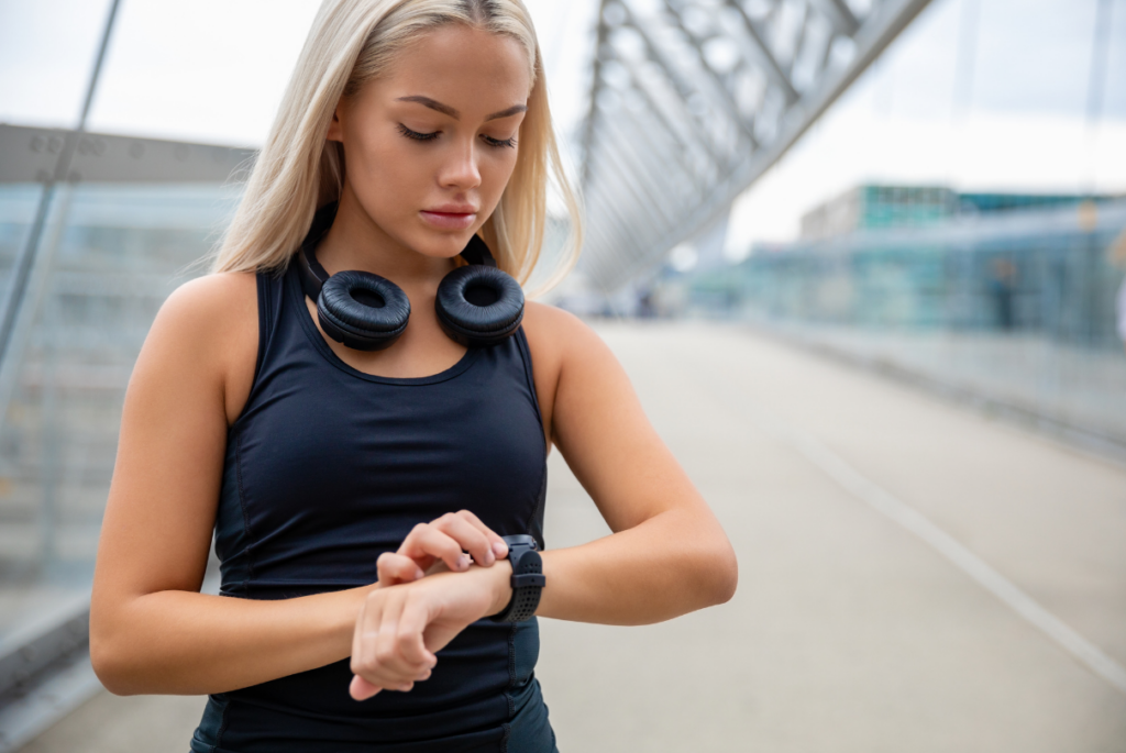 Menina mexendo no smartwatch antes de correr