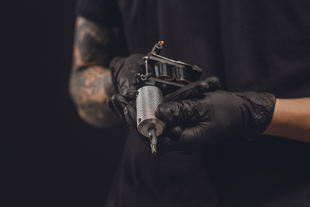 Tatuador segurando máquina de tatuagem