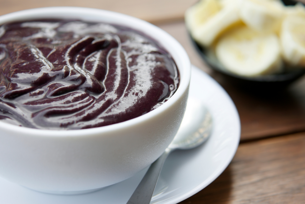 Tigela com açaí e bananas ao fundo