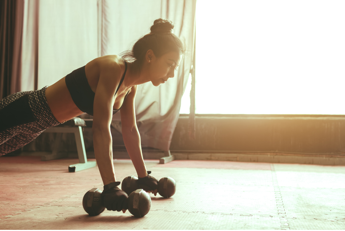 Mulher com halter pronta para fazer flexão de braço