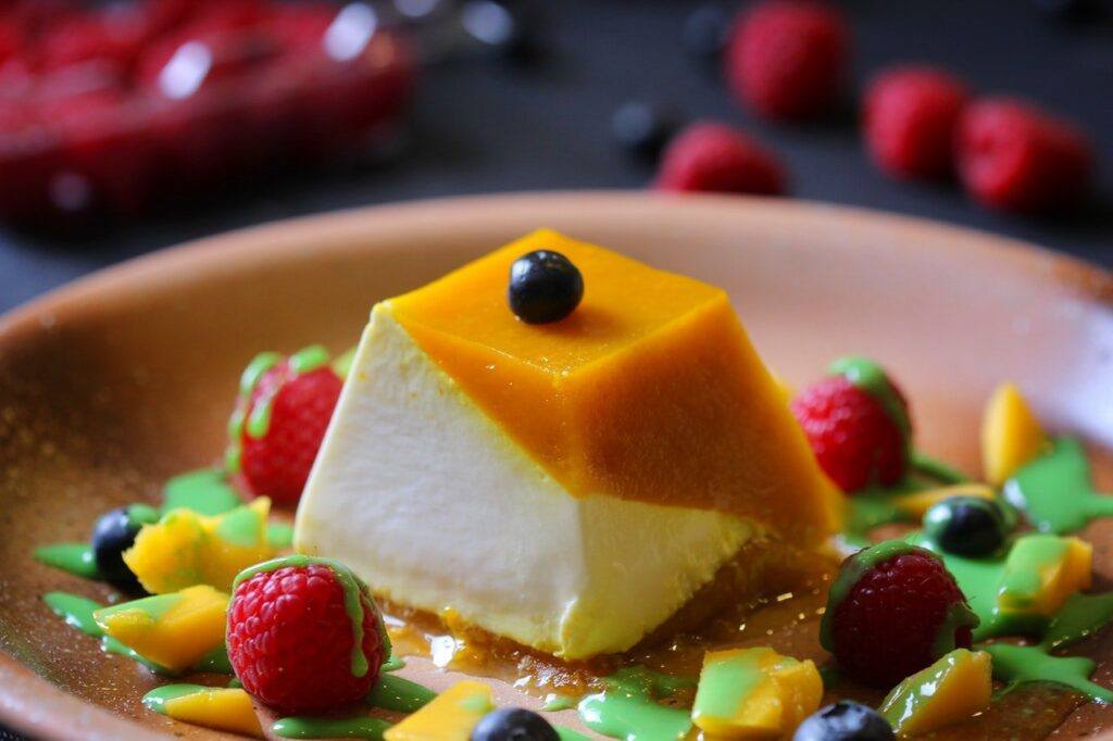 pudim furadinho envolvido por frutas em um prato