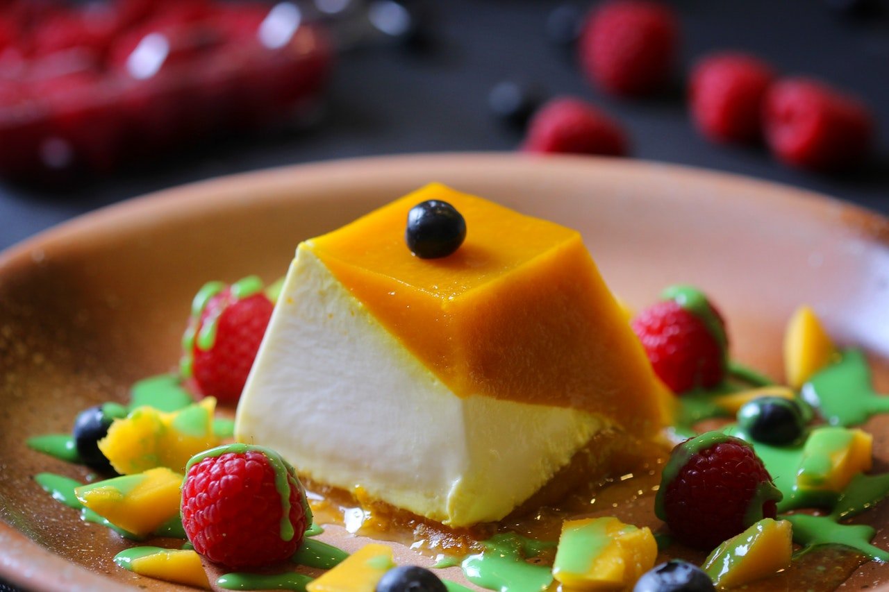 pudim furadinho envolvido por frutas em um prato