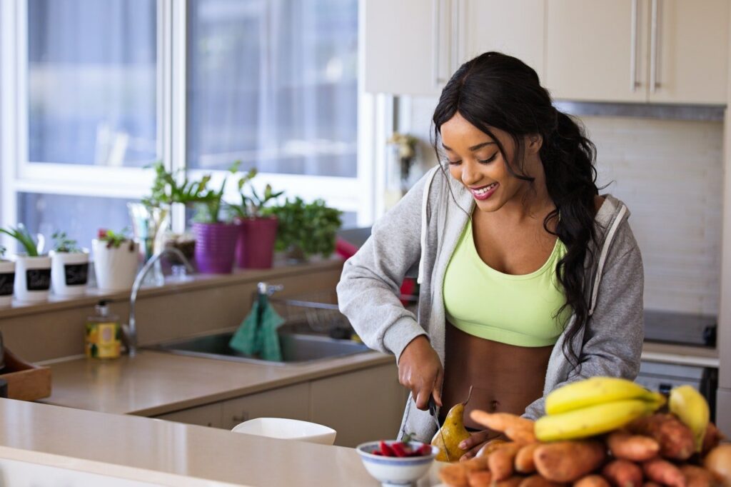 mulher cortando fruta na cozinha