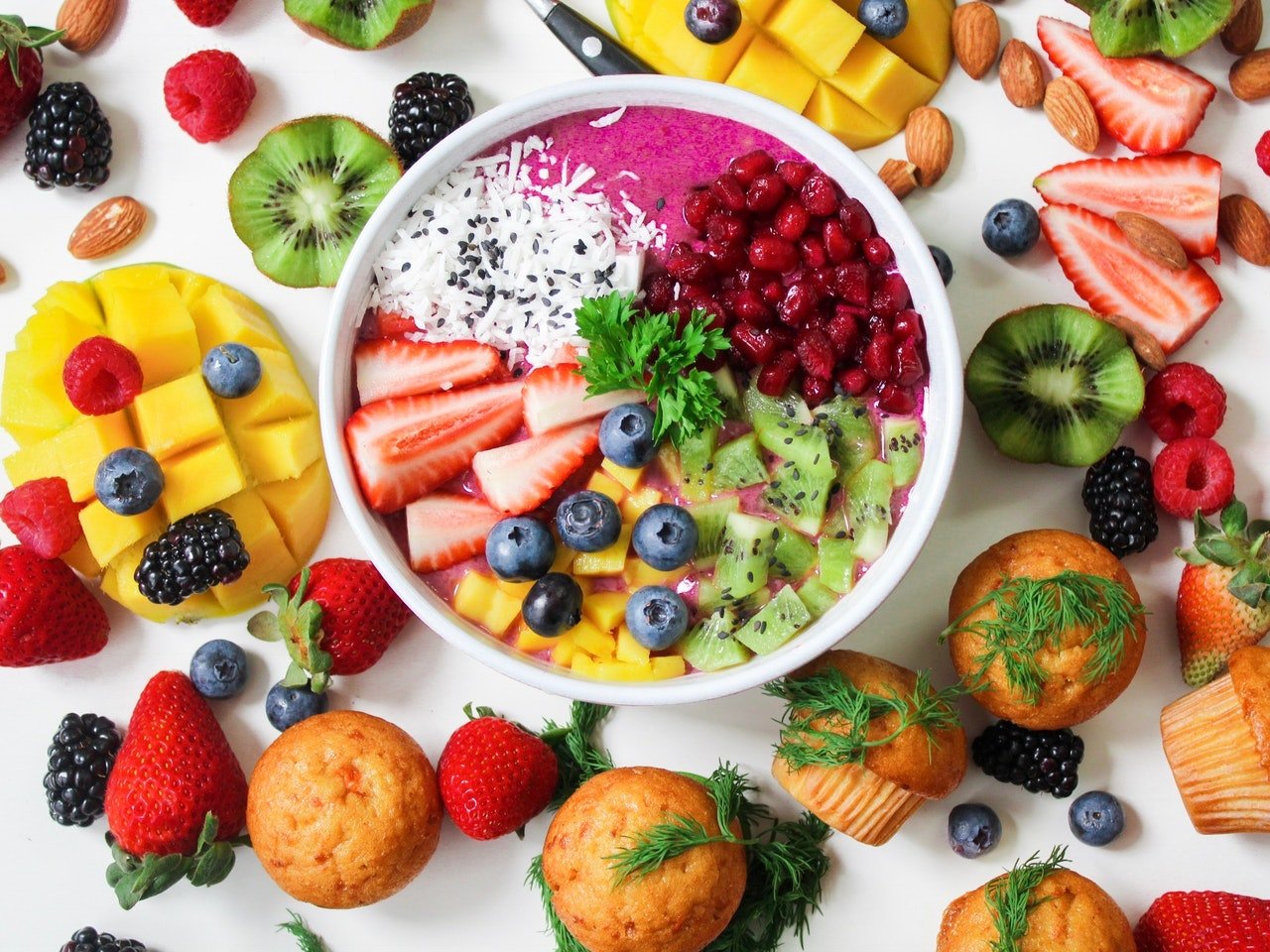 tigela com frutas e bolinhos em volta
