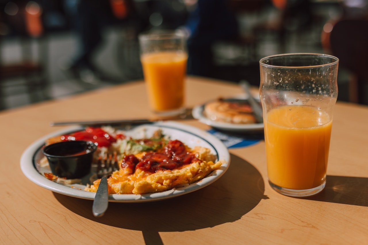 prato de omelete com molho e suco laranja